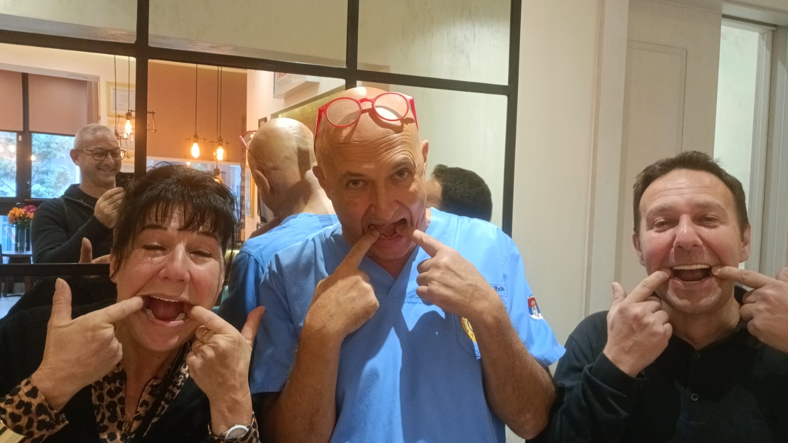Two patients and Prof. Dr. Stefan Ihde all smiling and showing their teeth, Belgrade clinic in September 2025